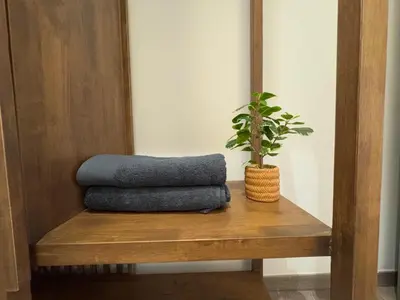a plant sitting on a wooden shelf with a pillow at Agile Bukit Bintang TRX KL by Lilbean Space - 2B1R in Kuala Lumpur