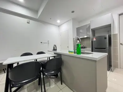 a kitchen with a counter with chairs and a refrigerator at Trion KL By Couple stay in Kuala Lumpur
