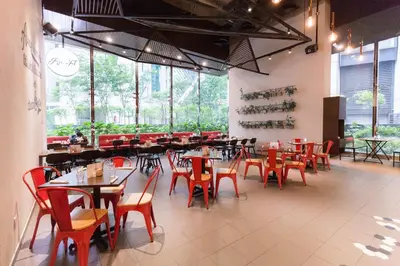 a dining room with tables and chairs and windows at Binjai 8 Signature by PSM in Kuala Lumpur