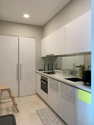 a kitchen with white cabinets and a counter top at Sky suites KLCC Level 58, 600Mbps WiFi - 2R plus 1BB in Kuala Lumpur