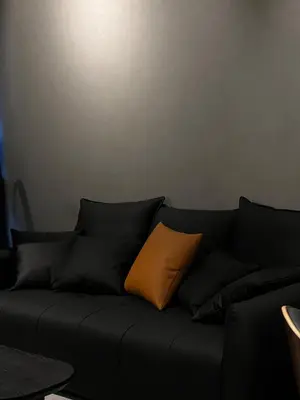 a black couch with an orange pillow on it at Luxury Black Suite Agile Bukit Bintang in Kuala Lumpur