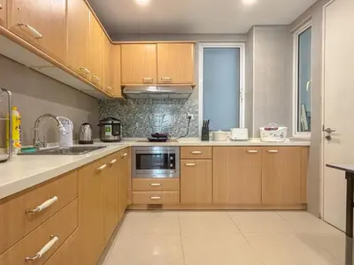 a kitchen with wooden cabinets and a sink at Bintang Goldhill, 5M to TRX in Kuala Lumpur