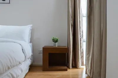 a bedroom with a bed and a table with a plant on it at Bintang Goldhill, 5M to TRX in Kuala Lumpur