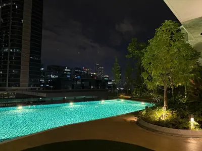 a swimming pool on the roof of a building at night at Cozy Urban Retreat in the Heart of the Bangsar in Kuala Lumpur