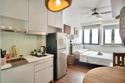 a kitchen with a refrigerator and a bedroom with a bed at Cozy Studio l Riveria City l 1km to KL Sentral in Kuala Lumpur