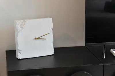 a clock sitting on top of a dresser next to a tv at Cozy Unit l Agile BB l 5min walk to TRX Pavilion in Kuala Lumpur