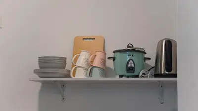 a shelf with cups and plates and a tea pot at Homey 2BR l Neu Suites l 5min to KL City in Kuala Lumpur