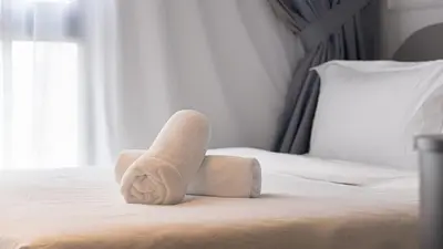 a rolled up towel sitting on top of a bed at Homey 2BR l Neu Suites l 5min to KL City in Kuala Lumpur