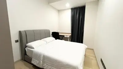a bedroom with a bed with white sheets and a desk at One Star KLCC in Kuala Lumpur