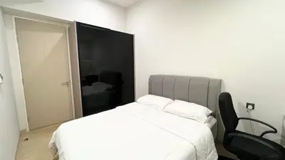 a bedroom with a white bed and a black chair at One Star KLCC in Kuala Lumpur