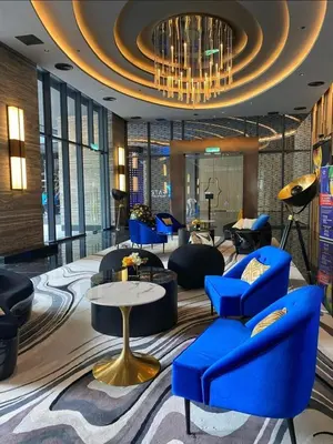 a lobby with blue chairs and a chandelier at One Star KLCC in Kuala Lumpur