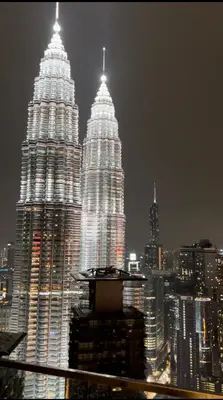 two tall towers in a city at night at One Star KLCC in Kuala Lumpur