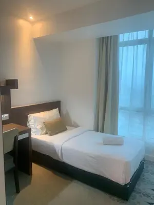 a bedroom with a bed and a desk and a window at RaarFAM Homestay in Kuala Lumpur