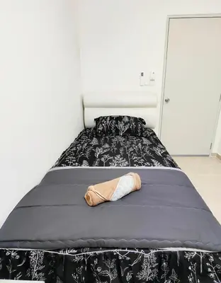 a bed with a black and white comforter and a shoe at Inap KL in Kuala Lumpur