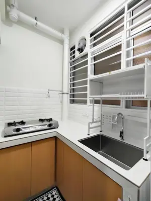 a white kitchen with a sink and a stove at Inap KL in Kuala Lumpur