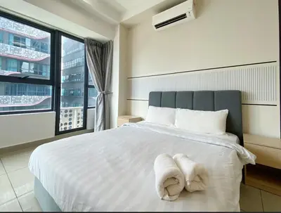 a bedroom with a white bed with towels on it at Arte Plus Ampang By Couple Stay in Batu Empat
