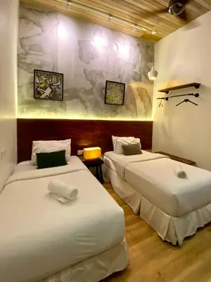 two beds in a room with white sheets at Chaos Boutique Hotel Kuala Lumpur in Kuala Lumpur