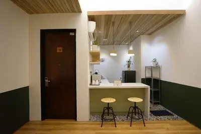 a kitchen with a counter and stools in a room at Chaos Boutique Hotel Kuala Lumpur in Kuala Lumpur