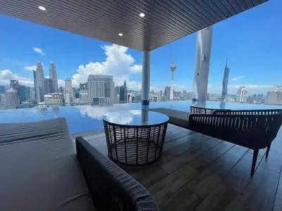 a balcony with a glass table and a view of the city at Maxhome Retreat at The Luxe in Kuala Lumpur