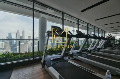 a gym with cardio machines and a view of the city at Maxhome Retreat at The Luxe in Kuala Lumpur