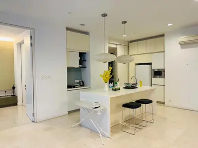 a kitchen with white cabinets and a counter with stools at Platinum Suites KLCC By Premium Hospitality in Kuala Lumpur
