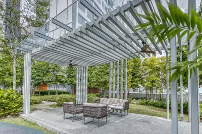 a wooden pergola with chairs and a table at Agile Residence Bukit Bintang, TRX by Isabella in Kuala Lumpur