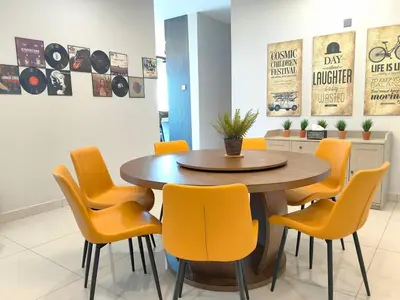 a dining room with a wooden table and yellow chairs at B3A l KLCC TRX Contemporaryl 17 Pax in Kuala Lumpur