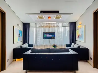 a living room with blue couches and a tv at Vortex Suites Klcc By VIP SUITES in Kuala Lumpur