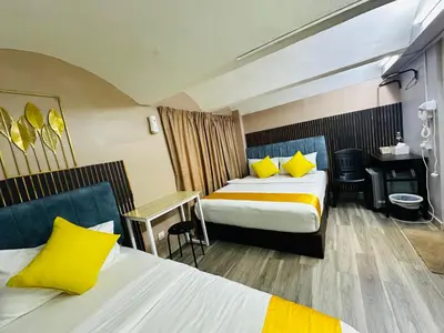 a hotel room with two beds and a desk at SS Grey Hotel kL in Kuala Lumpur