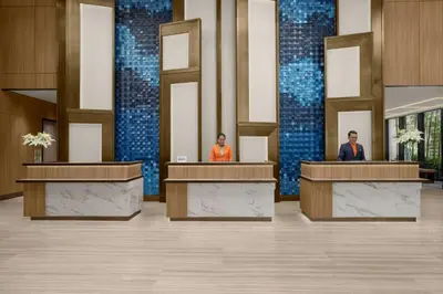 two people standing at podiums in a lobby at Marriott Executive Apartments Kuala Lumpur in Kuala Lumpur