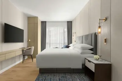 a bedroom with a large white bed and a desk at Marriott Executive Apartments Kuala Lumpur in Kuala Lumpur