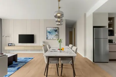 a kitchen and living room with a table and chairs at Marriott Executive Apartments Kuala Lumpur in Kuala Lumpur
