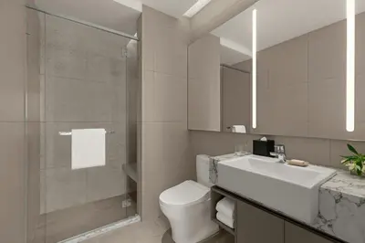 a bathroom with a sink and a toilet and a mirror at Marriott Executive Apartments Kuala Lumpur in Kuala Lumpur
