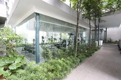 a building with glass walls and tables and plants at Summer Suite KL City Balcony Room KL Tower View in Kuala Lumpur
