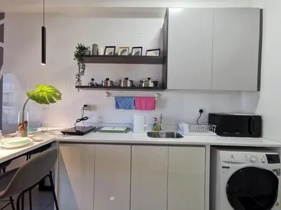 a kitchen with white cabinets and a dishwasher at Arte Plus Ampang 2BR Family Suite - Living Signature in Kuala Lumpur
