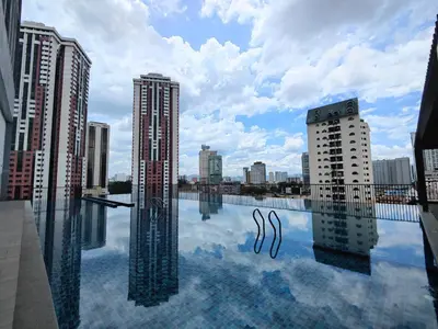 a view of a city from a pool of water with buildings at Lovely Studio room in KL in Kuala Lumpur