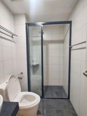 a bathroom with a toilet and a glass shower stall at Lovely Studio room in KL in Kuala Lumpur