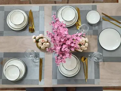 a table with white plates and flowers on it at Lovely Studio room in KL in Kuala Lumpur