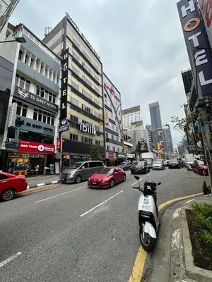 a scooter parked on the side of a city street at SS Grey Hotel BB in Kuala Lumpur