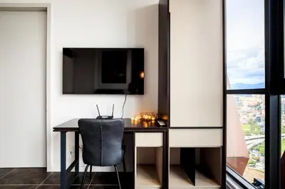 a room with a desk with a chair and a tv at Scarletz Suite By Skyscraper in Kuala Lumpur