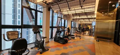 a gym with people exercising on ellipticals and exercise bikes at Scarletz Suite By Skyscraper in Kuala Lumpur