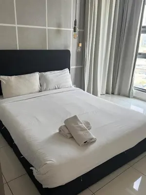 a bed with white sheets and towels on it at Robertson Special Suites By Luna in Kuala Lumpur