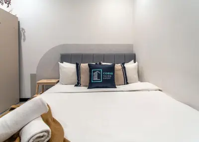 a bedroom with a bed with a black pillow on it at Neu Suites KL with Daily Breakfast Included in Kuala Lumpur