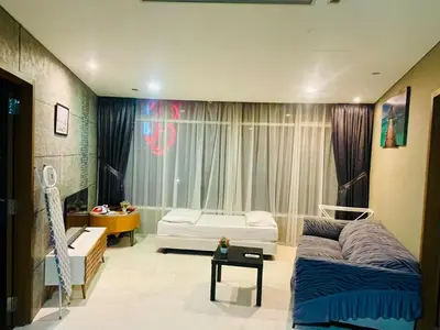 a living room with a couch and a bed and a window at Vortex klcc by Elham in Kuala Lumpur