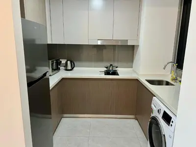 a kitchen with white cabinets and a sink and a dishwasher at Agile Bukit Bintang By Comfort Suites in Kuala Lumpur