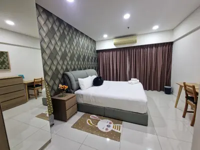 a hotel room with a bed and a table and chairs at Summer Suites Klcc 2BR Apartments by ATIQ in Kuala Lumpur