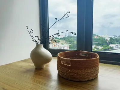 a white vase and a basket on a table with a window at Cozy Studio l Riveria City l 1km to KL Sentral in Kuala Lumpur
