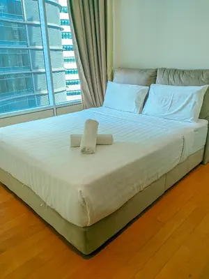 a bed with two towels on it with a window at Sky Suites KLCC Kuala Lumpur LB in Kuala Lumpur