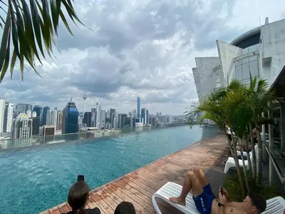 a swimming pool on the roof of a building with a city at Infinity Sky pool hostel best in Kuala Lumpur