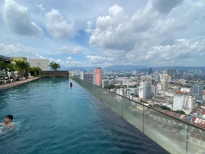 a man swimming in a infinity pool on top of a building at Infinity Sky pool hostel best in Kuala Lumpur